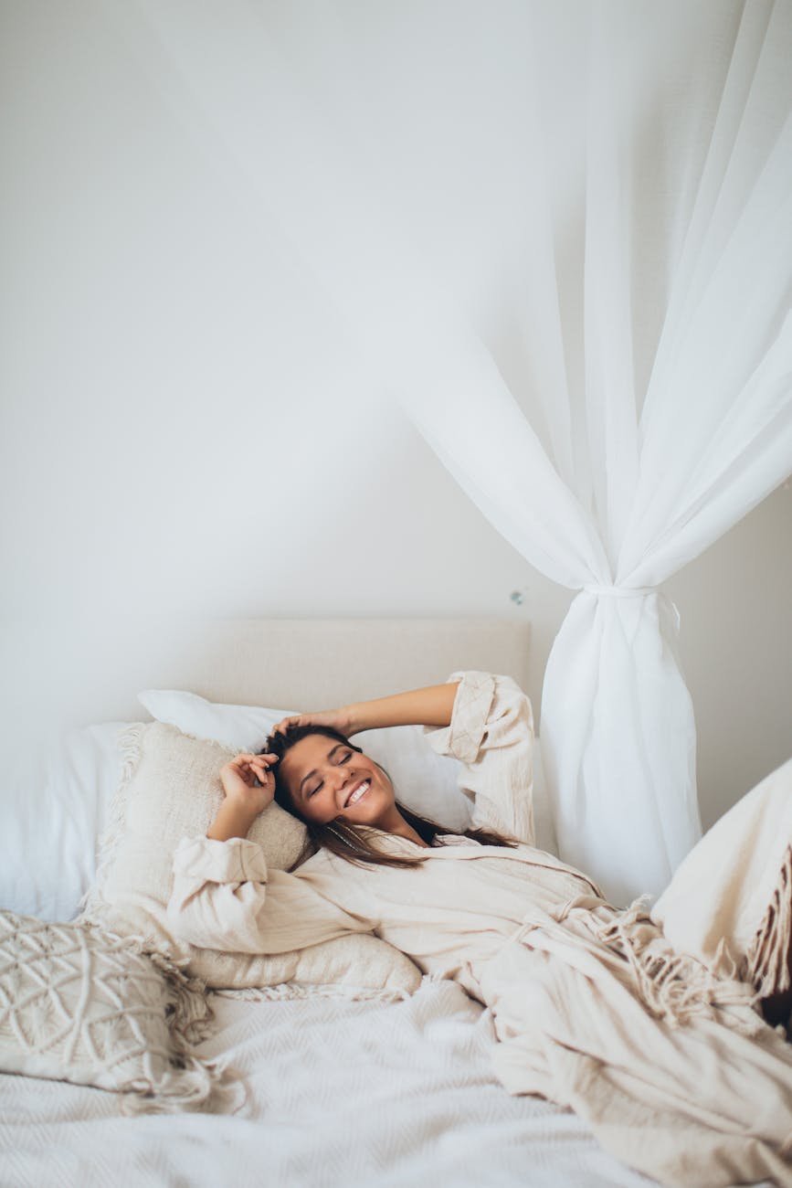 a smiling woman lying on the bed